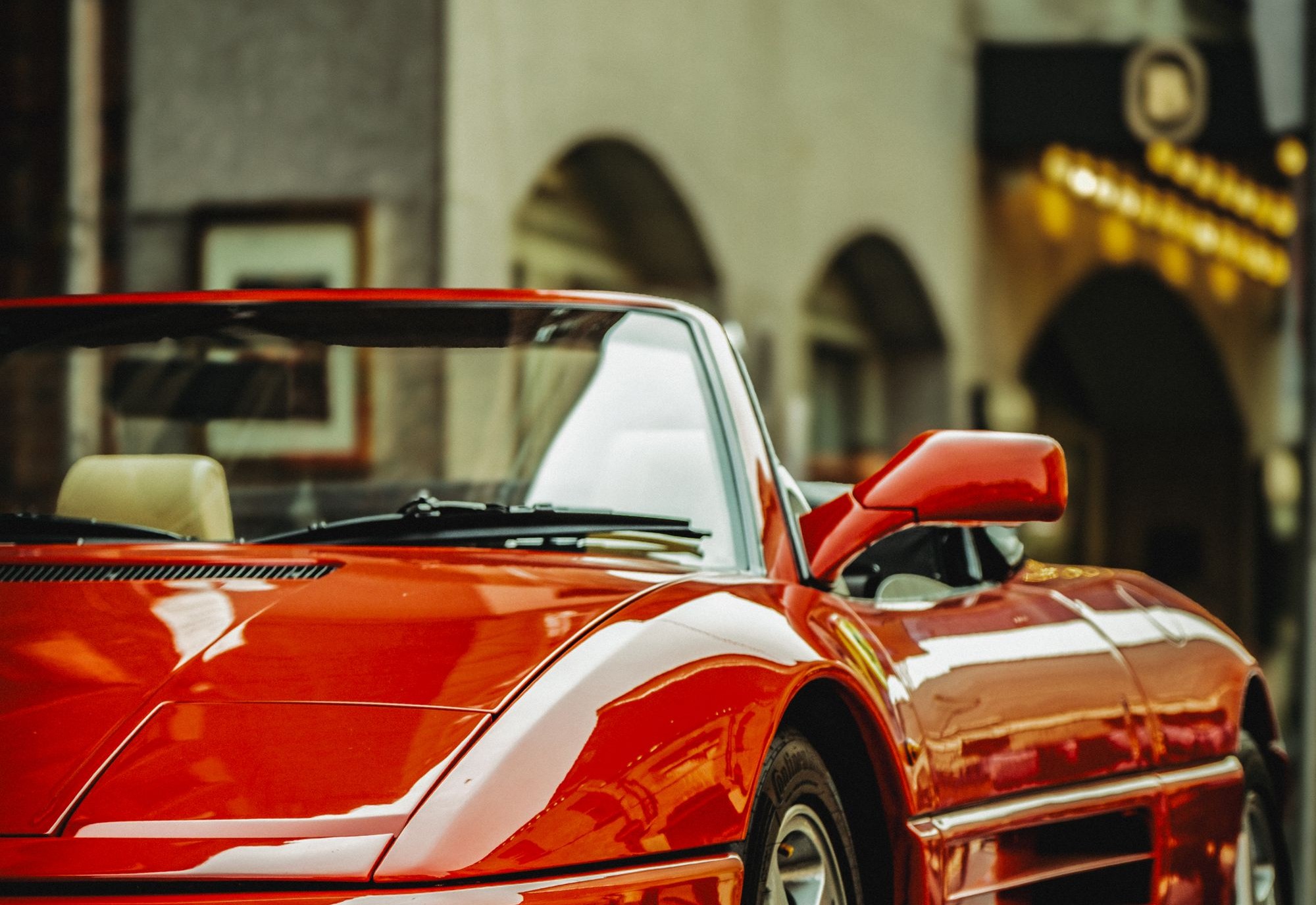 Ferrari rouge dans une rue historique, location de supercar sans chauffeur